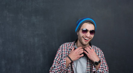 Handsome DJ posing in studio on dark background with headphones