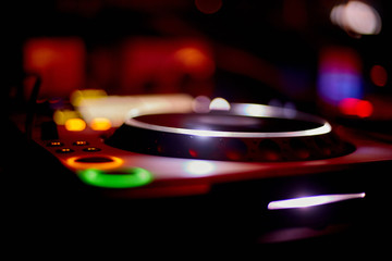 Fototapeta na wymiar Night Club DJ playing mixing music on turntable at party