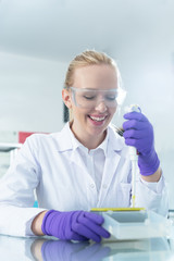Fototapeta premium Young scientist in white uniform working in laboratory