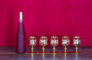 bottle of red wine and five glasses