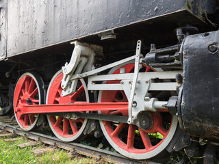 Old steam locomotive wheels and rods closeup