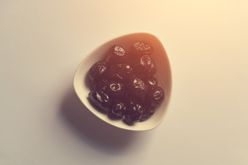 Small plate with black dates on a white background. Toned