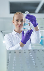 doctor female researcher holding up a test tube in labaratory