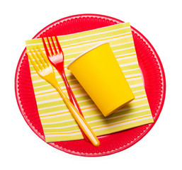 Bright disposable plates, paper cups, plastic forks napkin isolated.