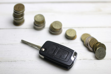 car key and coin on background