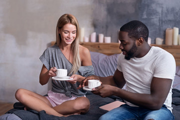 Cute couple having breakfast in bedroom together