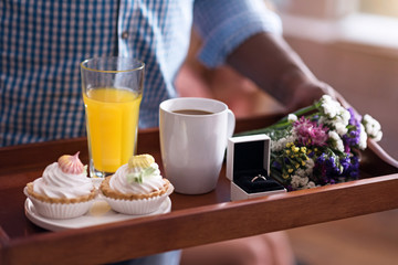 Close up of tray with wedding ring held by man