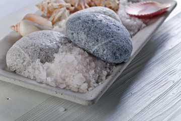 Sea salt with stones and shells on a old wooden table