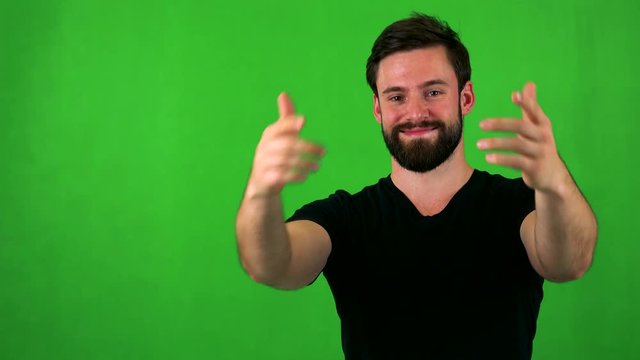 young handsome bearded man welcomes - green screen - studio
