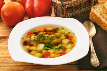 Transparent vegetarian soup with bean and vegetables.
