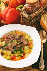 Transparent meat soup with bean and vegetables.