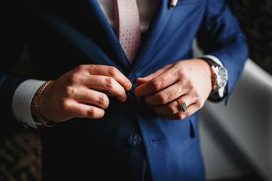 Closeup of man buttoning his jacket, business clothing concept