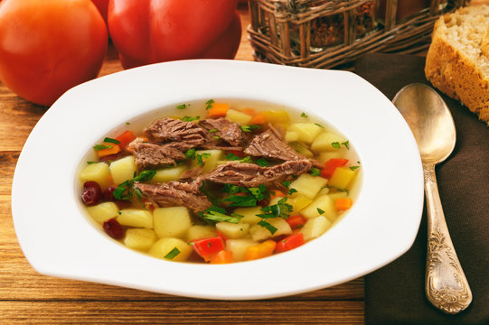 Transparent meat soup with bean and vegetables.