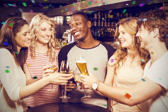 Composite image of cheerful friends toasting with beer and wine