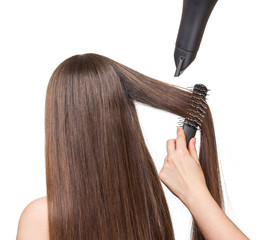 Fototapeta premium Girl with long hair, comb, hairdryer in hands hairdresser isolated.
