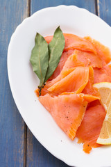 smoked salmon with lemon on white plate