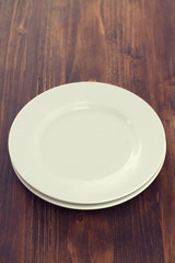 white plates on brown wooden background