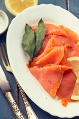 smoked salmon with lemon on white plate