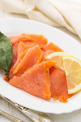 salted salmon with lemon on white dish