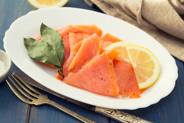 smoked salmon with lemon on white plate