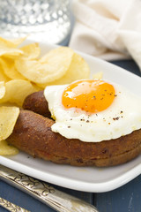 fried portuguese sausage alheira with egg and potato chips