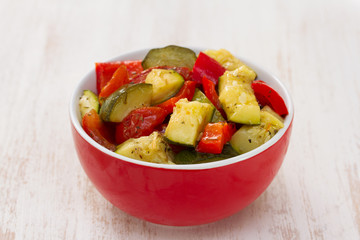 vegetables in red bowl on wooden background