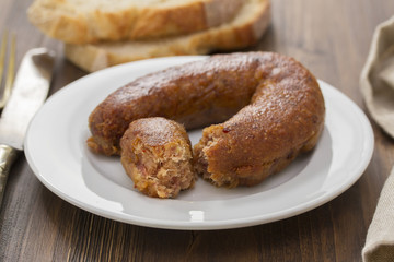 fried portuguese sausage alheira on white plate and bread