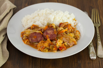 meat with cabbage,  beans and rice on white dish