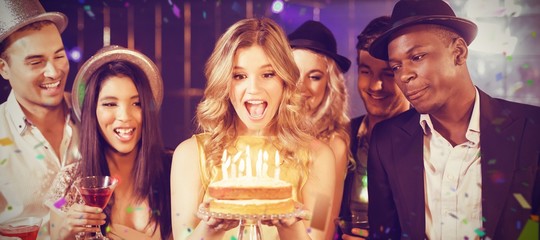 Composite image of happy friends celebrating birthday with cake