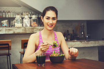 Attractive Caucasian fitness woman is eating salad with healthy glass of juice - Fitness and Diet concept