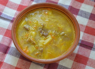 Meat soup with potatoes and noodle in an old ceramic plate