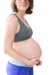 Close-up belly of a pregnant woman in sportswear