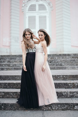 Portrait of two beautiful brunettes in long chiffon dresses stan