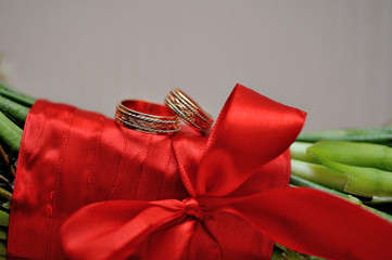 two golden rings on a bride's wedding bouquet