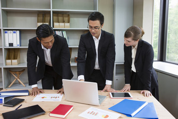 パソコンを見ながら話し合いをするビジネスパーソン