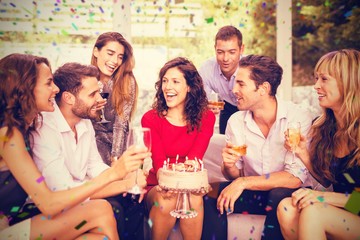 Composite image of cheerful woman celebrating her birthday with 