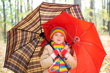 girl child in autumn forest with umbrella, beautiful landscape in fall season with yellow leaves