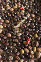 Baking fresh, colorful, organic olives, with rosemary, red hot peppers and mediterranean herbs, close-up, selective focus, space for text