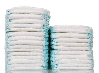 Stacks of disposable diapers closeup isolated on white.