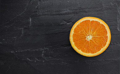 orange fresh cut on black stone. focus on orange fresh cut. with copy space for your text 