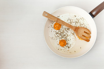 Fried eggs in the frying pan,breakfast ingredients.Cooking morning food.White Background.Top View.Food Texture