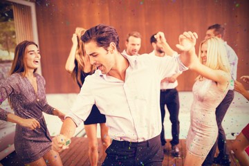 Composite image of cheerful friends dancing in party
