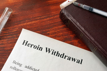 Heroin withdrawal written on a paper. Drug addiction concept.