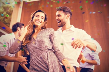 Composite image of cheerful young friends dancing together
