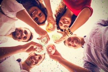 Composite image of directly below shot of friends having cocktai