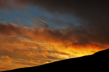 Beautiful sunset and orange sun lights above the mountains.