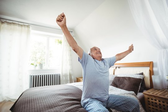 Senior Man Yawning On Bed