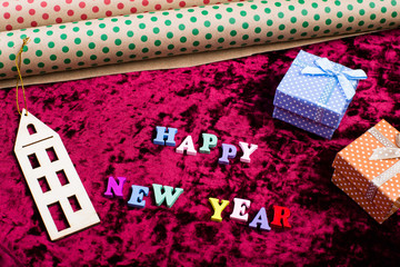 Inscription "Happy New Year" on velvet background, christmas decorations, gift boxes and wrapping paper