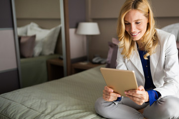 Businesswoman using tablet in bedroom