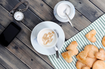 Foods of the Italian breakfast with coffee milk and biscuits on an old wooden table